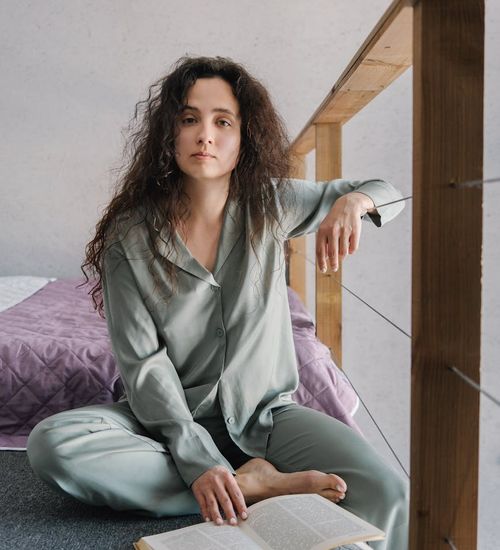 Person meditating peacefully indoors with soft light.
