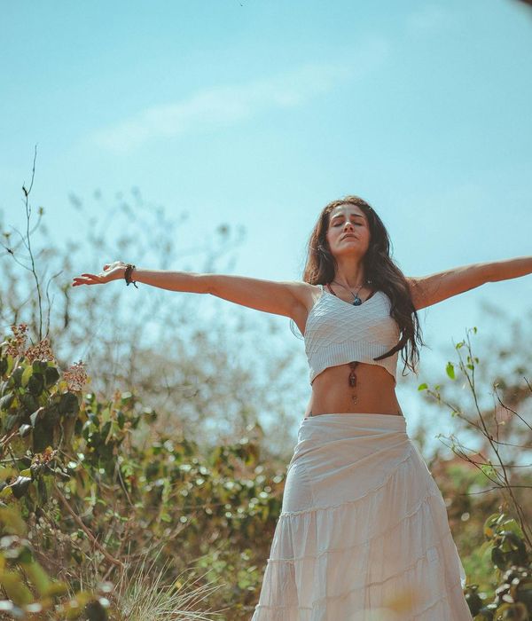 Woman performing a gentle stretching yoga pose in a calm environment.